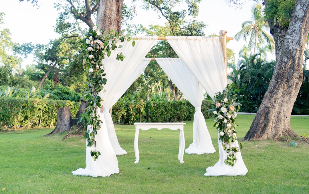 an-outdoor-wedding-setup-with-white-drapes-and-flowers-pmfcyjrqhn8
